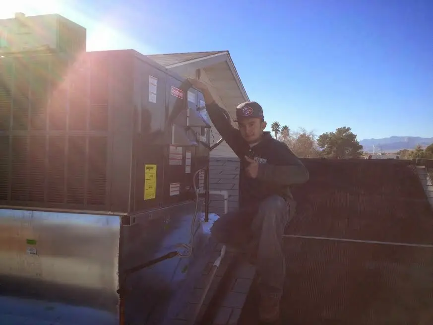 HVAC technician performing HVAC Inspection on a rooftop unit in Gretna